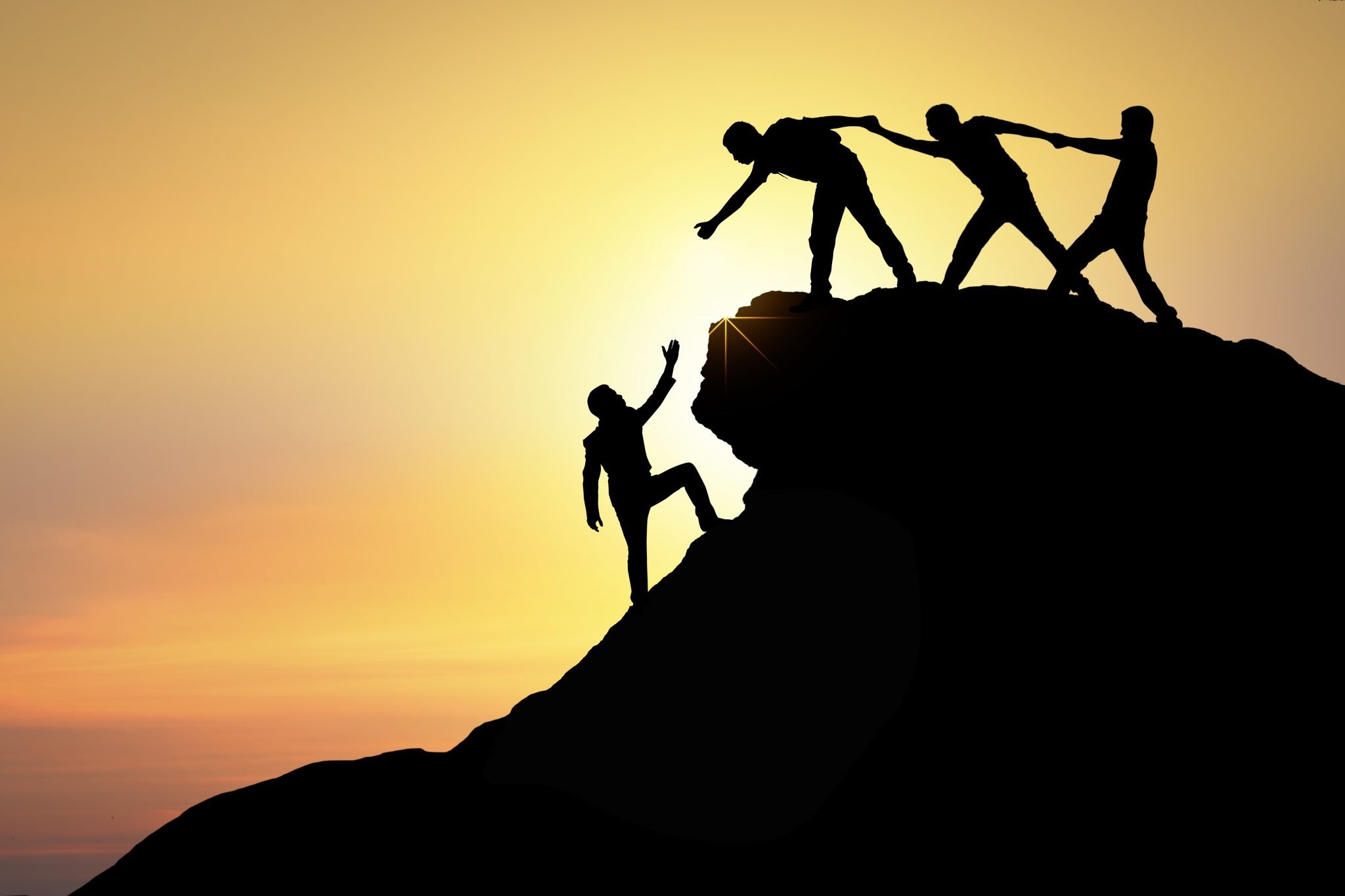 Menschen helfen sich auf einen Berg - das Wir-Gefühl