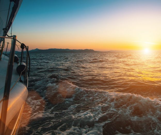 Zeit für Selbstreflexion: Ein Segelboot auf dem Meer im Sonnenuntergang.